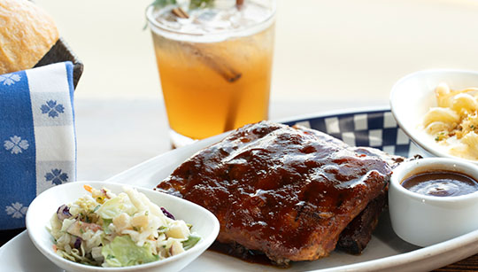 Duke's Seafood BBQ pork ribs basted with Duke's smoky sweet coffee-infused BBQ sauce served with house apple slaw and Cavatappi mac n cheese